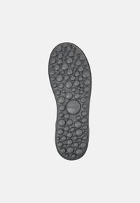 Black rubber shoe sole featuring a textured surface with circular, raised bubbles. Brand logo and size 38 printed on the sole.