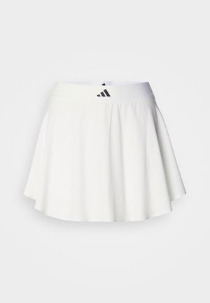 Λευκή αθλητική φούστα με φαρδιά, φουντωτή σχεδίαση, φτιαγμένη από ελαφρύ ύφασμα. Διαθέτει φαρδύ ζωνάρι μέσης με μαύρο λογότυπο.