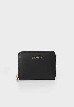 Black leather wallet featuring a zip closure and gold "LACOSTE" logo on the front, smooth texture with a rounded zipper pull detail.