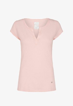 Haut pour femmes à manches courtes rose clair avec un encolure en V fendue et un petit logo rond métallique près de l'ourlet sur fond blanc.