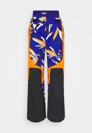 Pantalons de ski avec une base bleue ornée de motifs de feuilles orange et blanche, des accents noirs, des poches zippées et une taille ajustable par Velcro.