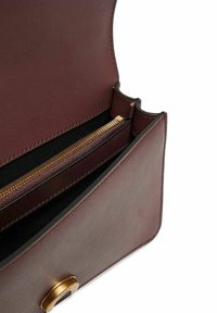 Borsa in pelle marrone con una texture liscia, dotata di una cerniera e chiusura dorate, e con un interno suddiviso da un rivestimento in tessuto.