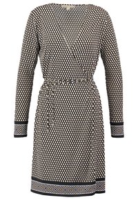 Wrap dress in dark fabric with cream polka dots, long sleeves, tie waist, and patterned accents on sleeves and hem.