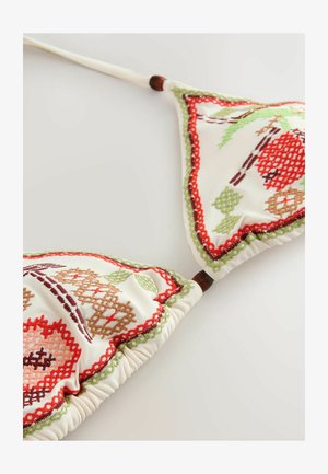 Top de bikini alb cu cupe triunghiulare, având broderie florală colorată în roșu, verde și maro, cu părți strânse și accente din lemn.