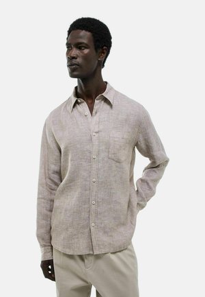 Chemise en lin marron clair à manches longues, avec un devant boutonné, une poche poitrine simple et une coupe décontractée. Présente une texture subtile et un tissage doux.