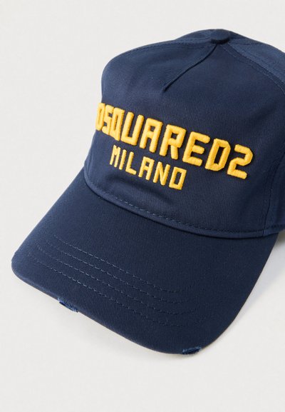 Gorra azul marino de tela, con texto bordado en amarillo "DSQUARED2 MILANO" en la parte frontal, con visera curva y detalles de costuras visibles.