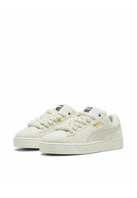 Baskets en daim blanc avec des lacets épais de style corde, semelles en caoutchouc et accent de marque doré. Design ergonomique avec un bout arrondi.