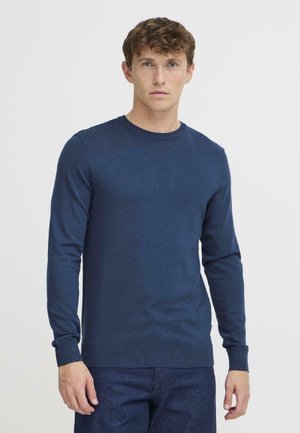 Marineblå strikkegenser med rund hals, lange ermer og ribbestrikkede mansjetter. Laget av et strukturert stoff med en tettsittende fasong.