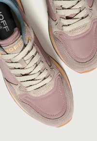 Zapatillas en suave púrpura claro y beige de ante con acentos de textil. Presentan un diseño de cordones, cordones planos texturizados y una puntera redonda.
