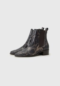 Botas de tobillo con estampado de piel de serpiente en negro y marrón, con paneles laterales elásticos, punta afilada y un bajo tacón cuadrado.