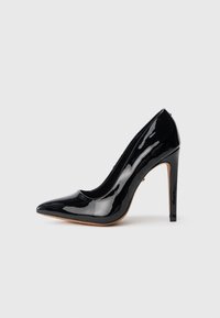 Pantof cu toc înalt din piele lacuită neagră, cu vârf ascuțit, siluetă elegantă și toc subțire de 10 cm. Textură netedă și lucioasă.