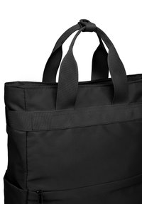 Schwarze Tragetasche aus strapazierfähigem Stoff, mit zwei kurzen Griffen und rechteckiger Form. Verfügt über eine strukturierte Oberfläche und verstärkte Nähte.