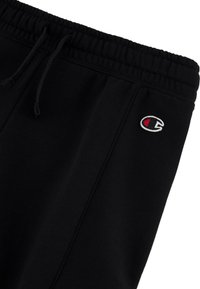Schwarze Jogginghose mit elastischem Bund und verstellbarem Kordelzug. Mit einem kleinen gestickten Logo auf der linken Seite. Weicher Stoff. 