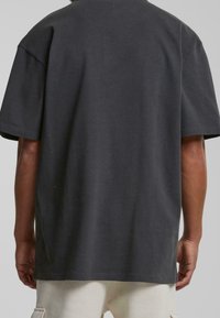 Dark grey short-sleeve t-shirt with a loose fit, rounded neckline, and soft cotton material. No visible logo or pattern.