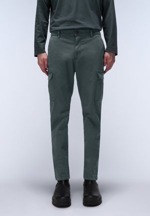 Cargo pants in dark green, made of smooth fabric, with two side pockets and a loose fit, paired with black shoes.