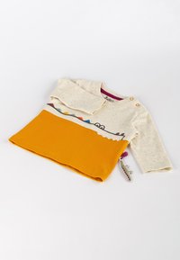 Langärmliges Kinderhemd; cremefarbener Oberteil mit bunten Sprenkeln, grafischem Muster, orangefarbenem Unterteil; verfügt über Knöpfe und ein Stichdetail.