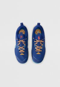 Baskets de sport bleues avec tige en mesh texturé, présentant des lacets orange, une semelle en liège et des accents bleu clair contrastants sur la semelle.