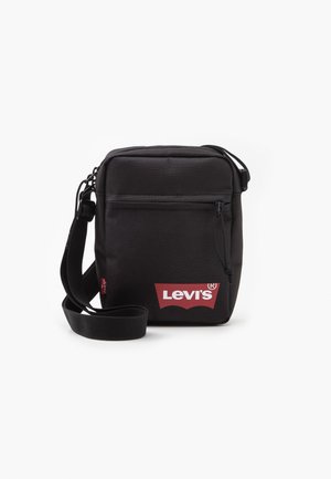 Czarna torba na ramię Levi's z regulowanym paskiem, przednią kieszenią na zamek i czerwonym logo Levi's na białym tle.