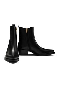 Schwarze Leder-Ankle-Boots mit glatter Oberfläche, spitzer Zehenpartie und seitlichem Reißverschluss. Sie verfügen über einen niedrigen Blockabsatz und eine Zuglasche an der Rückseite für ein einfaches An- und Ausziehen.