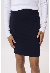 Falda ajustada azul marino hecha de material elástico, con una cinturilla suave y elástica y un corte a la altura de la rodilla. Sin bolsillos visibles.