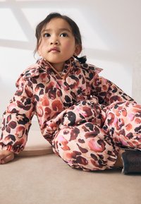 Gepolsterter Overall aus pinkem Stoff mit Leopardenmuster in Rot- und Schwarztönen. Mit Kragen und elastischen Bündchen.