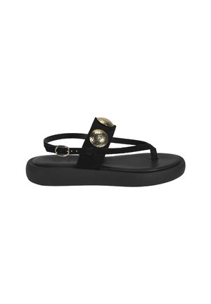 Zwarte suède sandaal met twee gouden decoratieve studs, dunne banden en een platte rubberen zool. Minimalistisch ontwerp met een elegante silhouette.