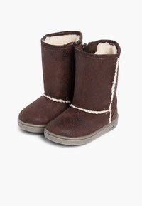 Botas de imitación de cuero marrón con un suave forro crema; cuentan con un acento de cuerda trenzada y una suela de goma con agarre texturizado.