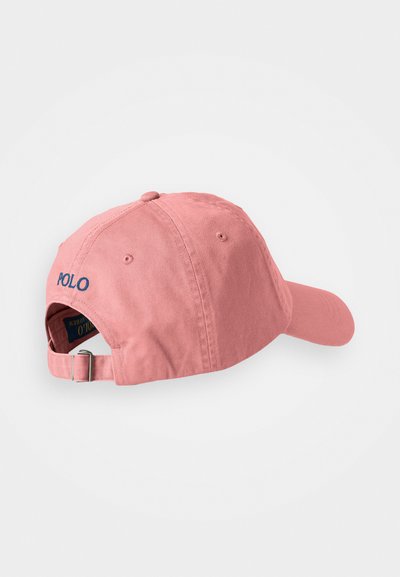 Pink cotton baseball cap with a curved brim and adjustable strap. Features embroidered "POLO" logo on the front in blue. Smooth texture.