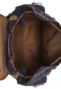Sac à dos à cordon de serrage bleu marine ouvert avec doublure intérieure marron et plusieurs compartiments intérieurs.