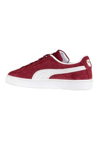 Sneaker in suede rosso con suola e dettagli in gomma bianca. Presenta un classico design con lacci, superficie texturizzata e accentuazione del logo.