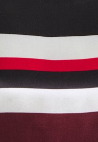 Stof med vandrette striber i sort, hvid, rød og bourgogne. Glat tekstur med en let glans, der fremhæver farvekonturerne.
