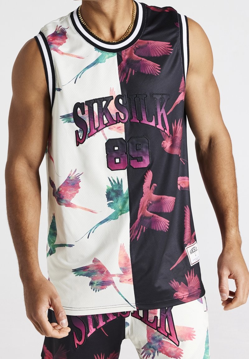 Maillot de basketball sans manches avec un design moitié blanc, moitié noir, imprimé d’oiseaux colorés, texte « SIKSILK 89 », porté par une personne avec une chaîne en or.