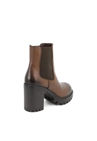 Stivaletto in pelle marrone con tacco alto a blocco, pannelli laterali in elastico e suola in gomma testurizzata, che mostra un design elegante e moderno.