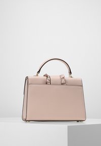 Rosa läderhandväska med en strukturerad form, handtag upptill och en rosettdetalj. Har en slät yta och detaljer i guldton.