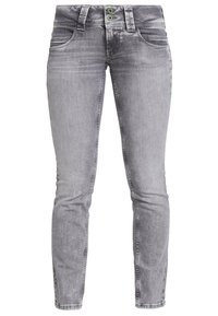 Jeans de mezclilla gris con corte slim, que presentan dos botones verdes como acento, diseño clásico de cinco bolsillos y un ligero desvanecimiento en toda la tela.