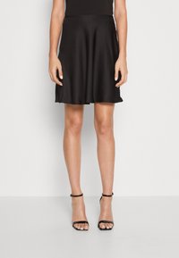 Svart, utsvängd kjol av slätt tyg, knälång, med en enkel design och bred midja samt mjuk fall.