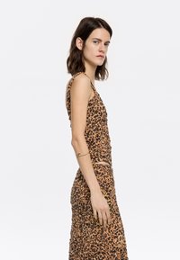 Leopardų rašto suknelė be rankovių, raukšlėta tekstūra ir midi ilgis. Spalvos: ruda, oranžinė ir juoda.