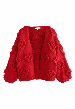 Red knitted cardigan with a V-neck, oversized sleeves, and textured pom-pom accents in a geometric pattern. Open front design.