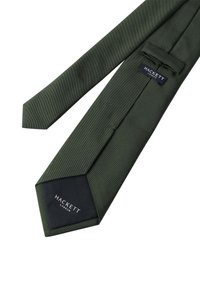 Corbata verde oscura con un patrón de ribetes texturizados. Cuenta con un extremo puntiagudo y una etiqueta negra con "HACKETT LONDON" en fuente blanca.