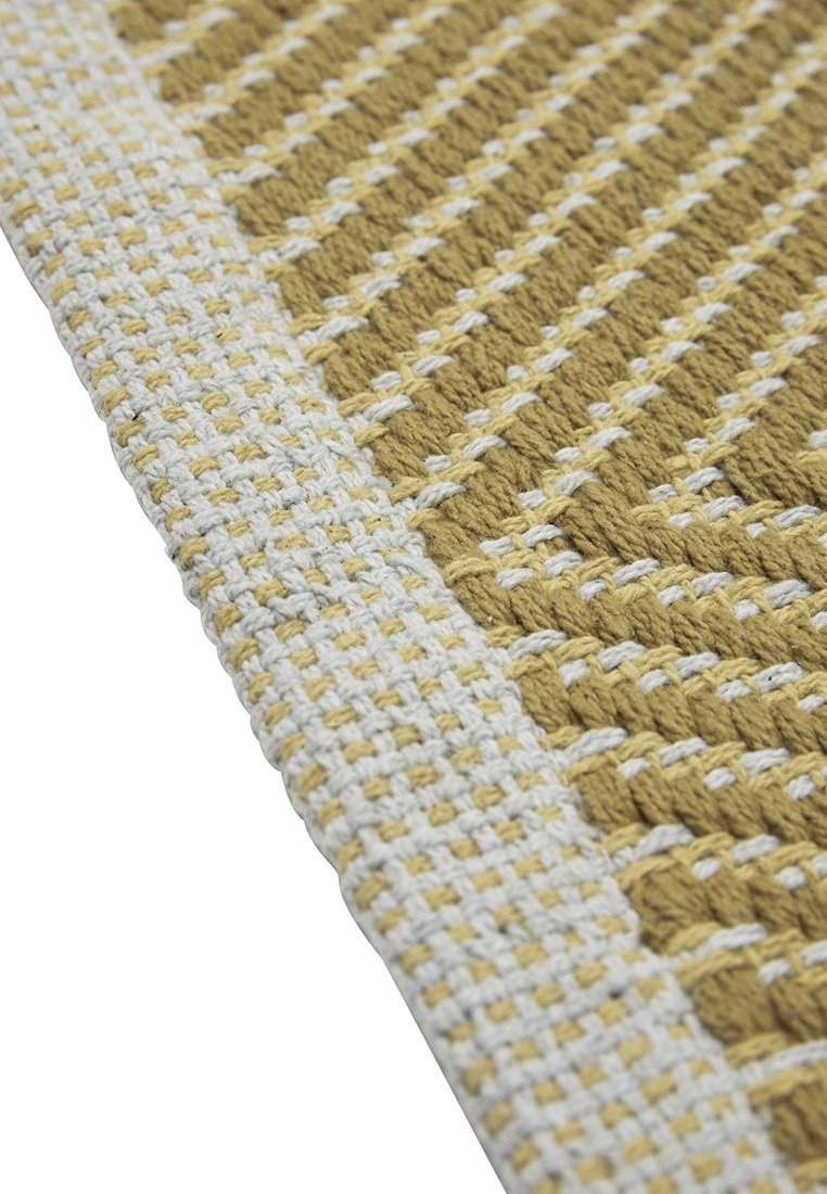 Tappeto in cotone intrecciato con un motivo geometrico in oro e bianco sporco, con una finitura testurizzata e un bordo bianco distintivo.
