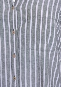 Camicia in lino con bottoni, caratterizzata da righe verticali grigie e bianche, una tasca sul petto e bottoni di colore naturale per la chiusura.