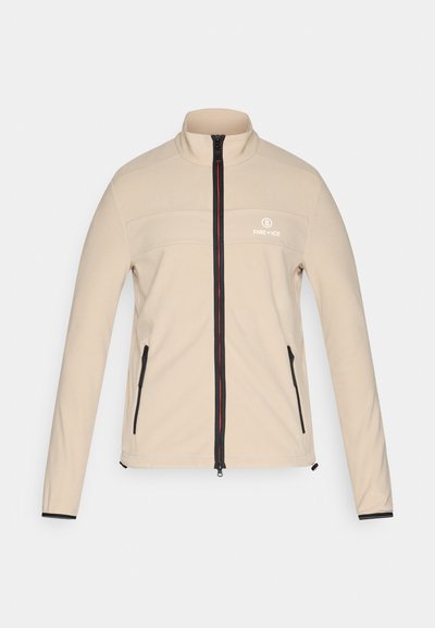 Beige Jacke mit durchgehendem Reißverschluss in Schwarz und Rot, zwei Reißverschlusstaschen und "Fire + Ice"-Logo auf der linken Brust.