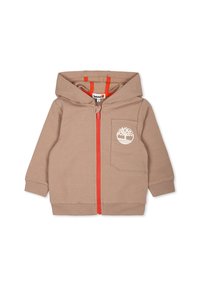 Felpa zip con cappuccio beige con zip arancione, tasca anteriore e logo bianco. Presenta una texture morbida e un cappuccio. Adatta per un abbigliamento casual.