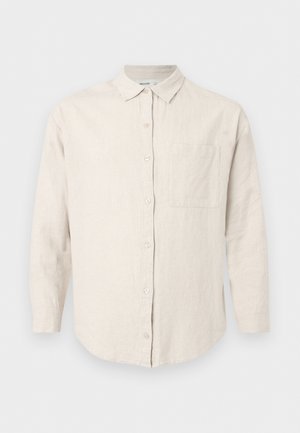 Beige long-sleeve button-up shirt with collar and chest pocket, made of textured fabric, displayed on plain white background.