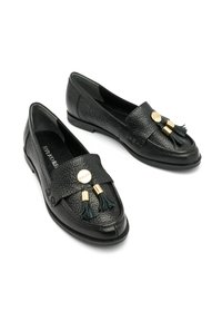 Czarne skórzane loafersy z teksturowanym wykończeniem, szerokim paskiem z złotymi akcentami i dwoma zielonymi frędzlami z przodu.