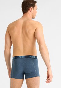 Bóxer de hombre en azul oscuro, confeccionado en algodón, con una suave cinta elástica en la cintura con logotipo en relieve y detalles de costura en contraste.