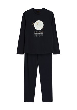 Conjunto de pijama negro de manga larga con un gráfico redondo en dorado y blanco, con texto debajo. La tela parece suave y lisa.