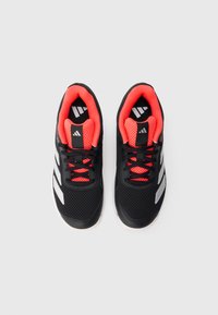 Par sorte sportsko med lyserød indre foring og hvide striber, set ovenfra på en hvid baggrund.