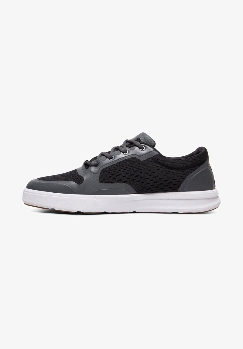 Black and grey athletic shoes with a mesh upper, rubber sole, six eyelets, and a textured toe cap. Side pattern features ventilation holes.
