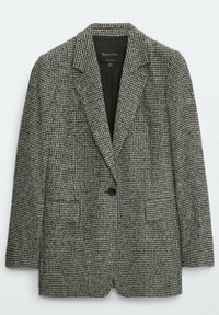 Zwart-wit geblokte blazer met een notch lapel, sluitsysteem met een enkele knop en twee voorkgedeelte zakken. Gemaakt van een gestructureerde stof.